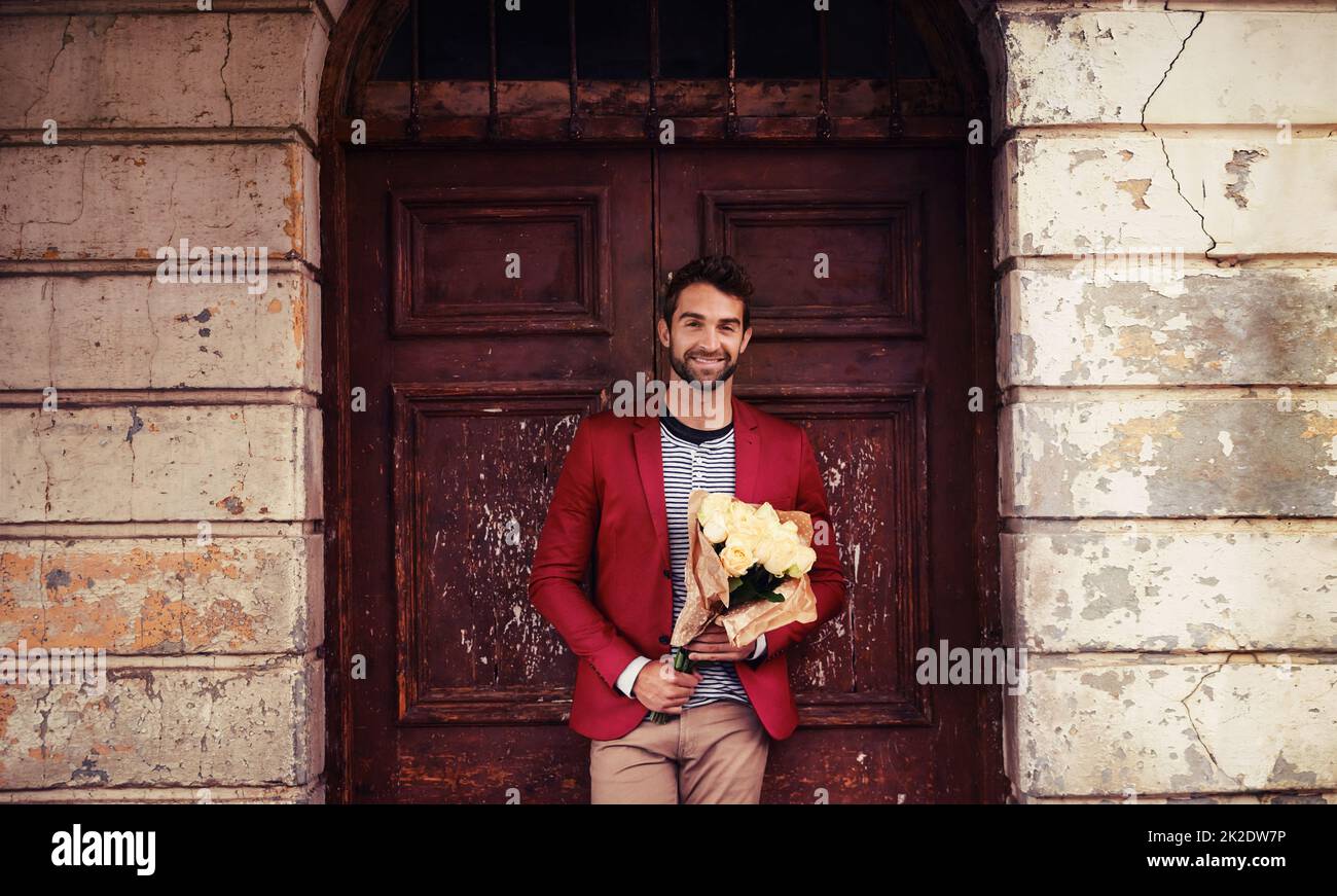 Chivalry is not dead. Shot of a handsome young urban man holding a bunch of flowers. Stock Photo