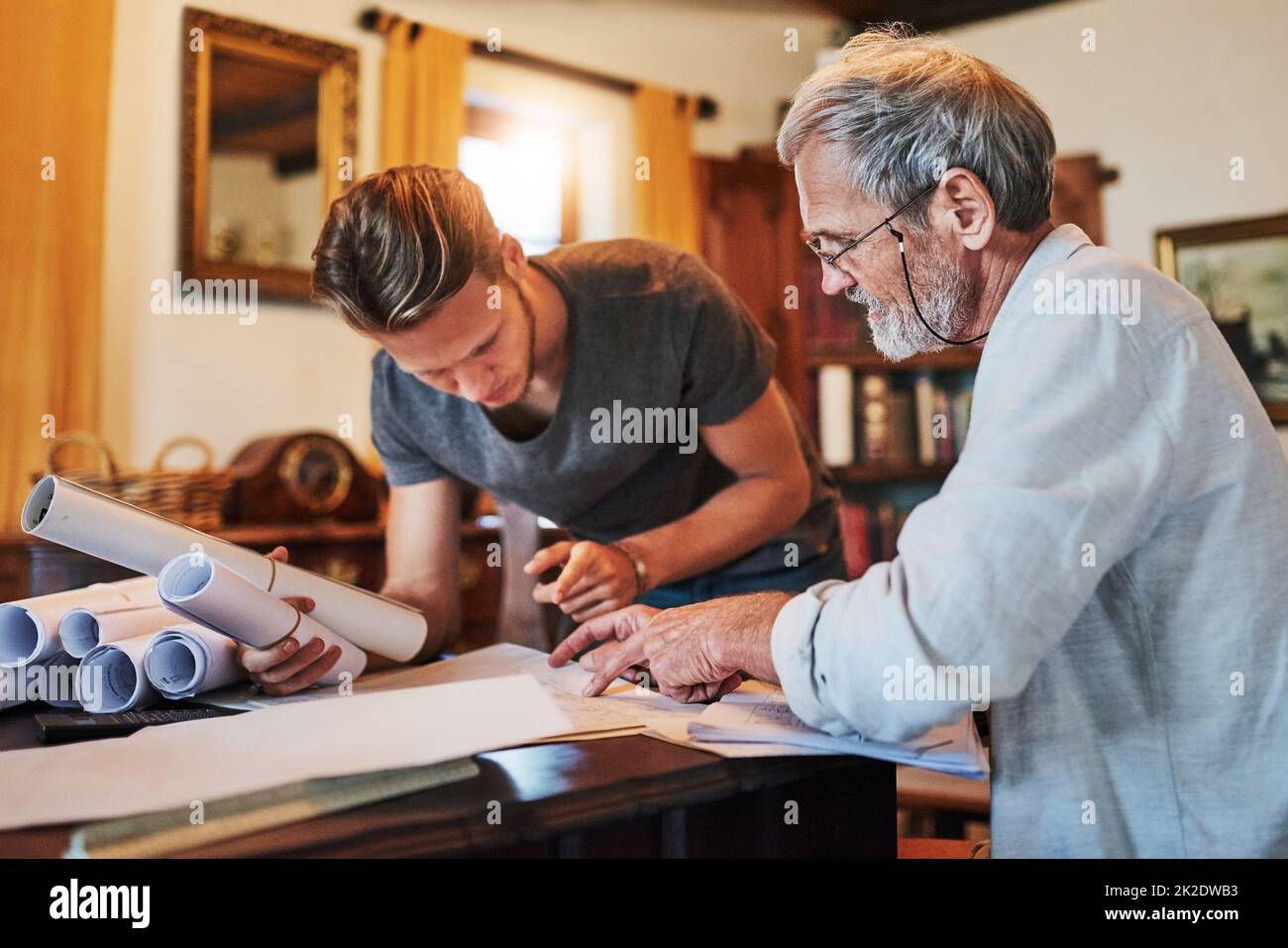 Hes joining the family business. Shot of two men working on a project together at home. Stock Photo