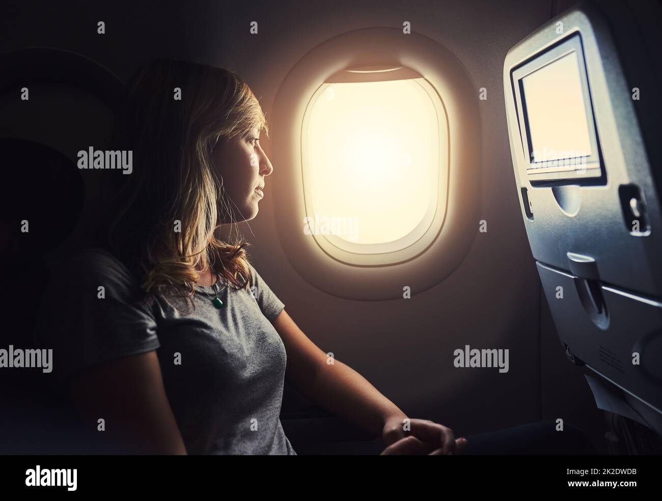 What a view. Shot of a young person in an airplane. Stock Photo