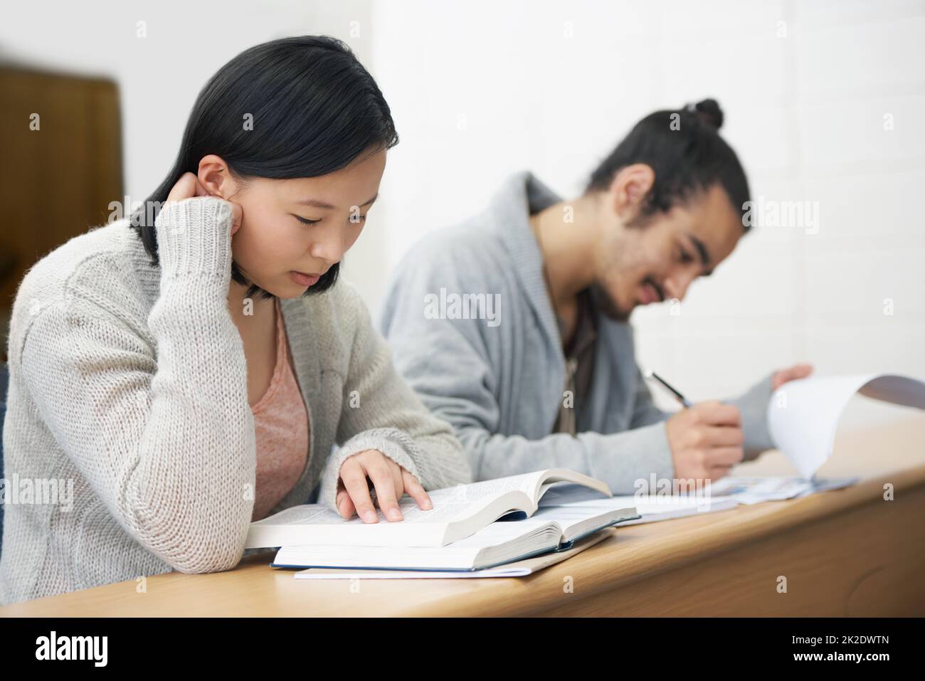 This test could change their lives for the worse or for the better.... Image of two students sitting in a lecture hall and studying for exams. Stock Photo