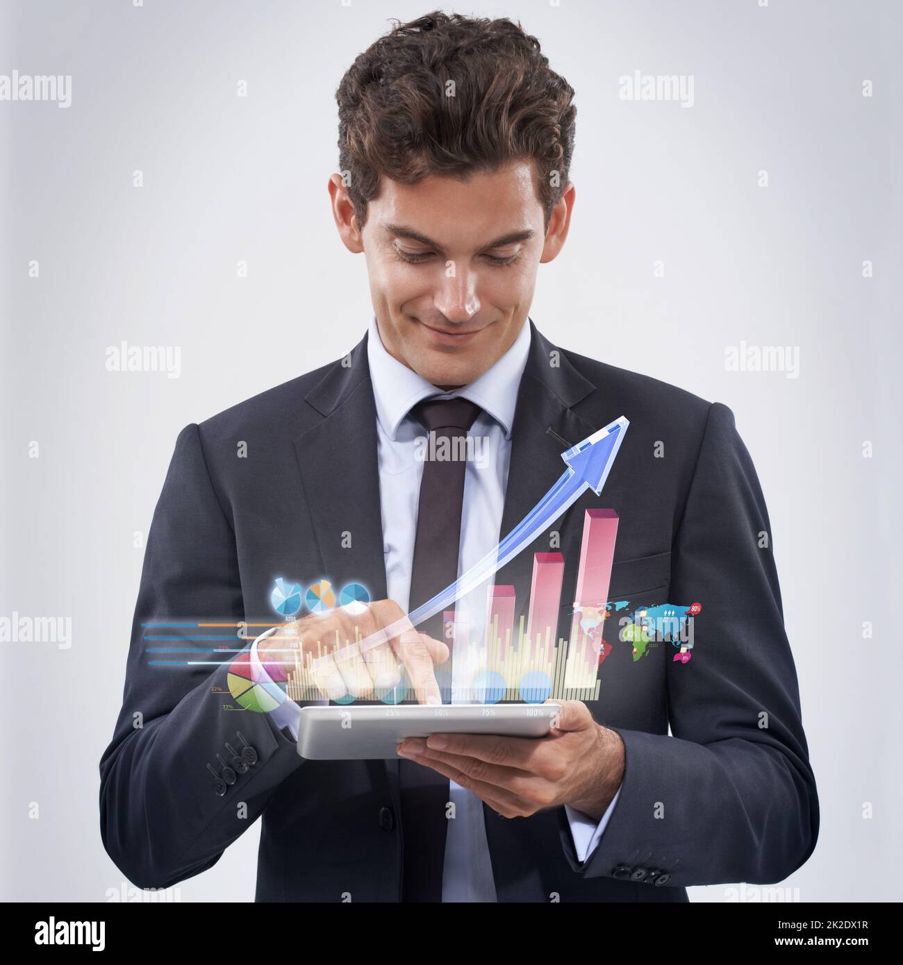 Your financial future is looking good. Studio shot of a young businessman analyzing data using his digital tablet. Stock Photo