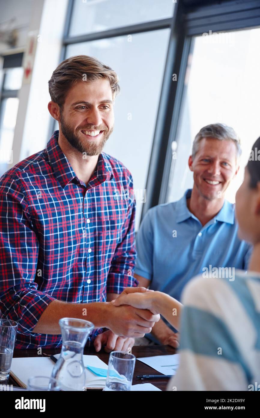 Good things come to those who wait. Shot of coworkers shaking hands in an office. Stock Photo