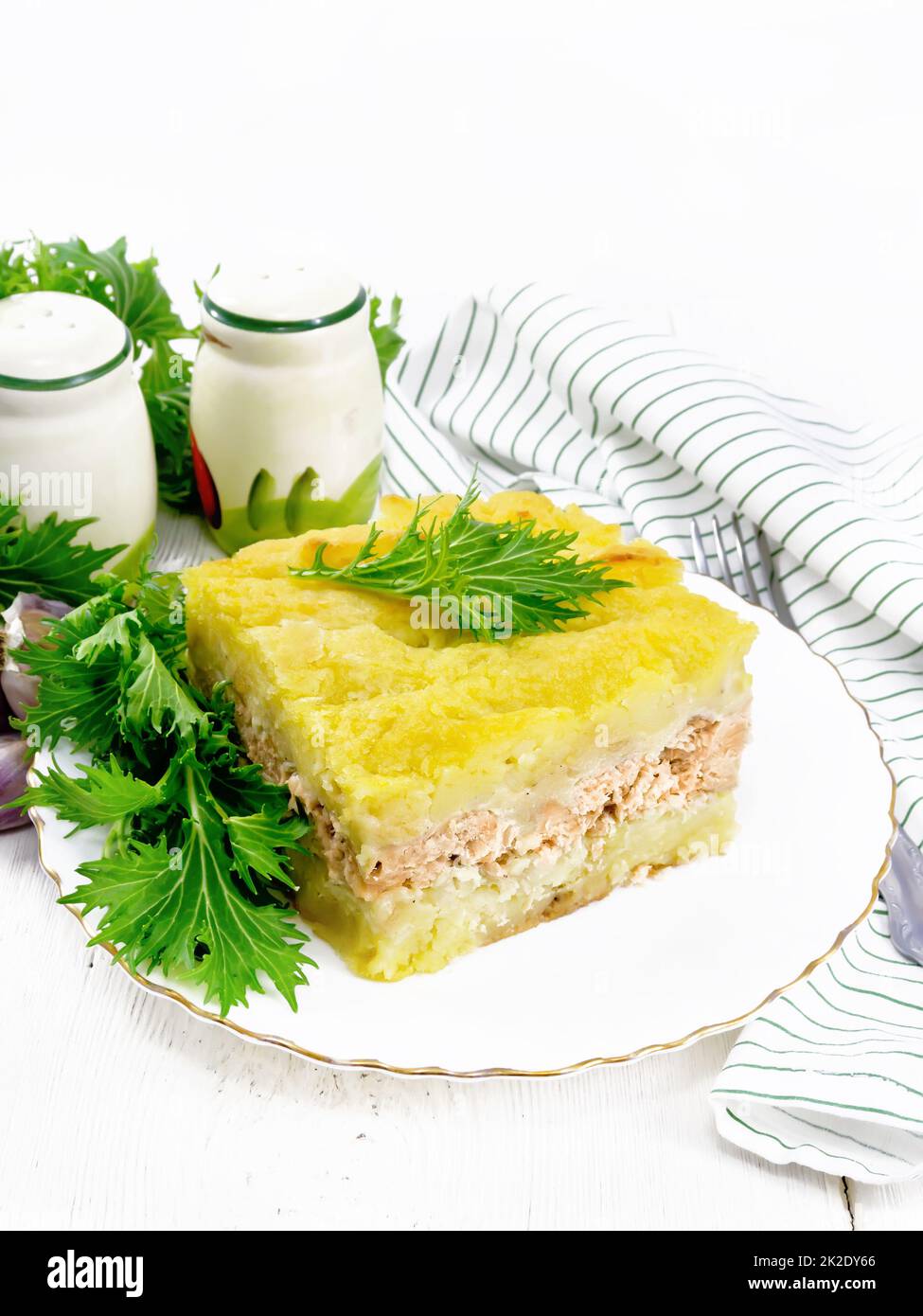 Casserole with potatoes and fish in plate on table Stock Photo