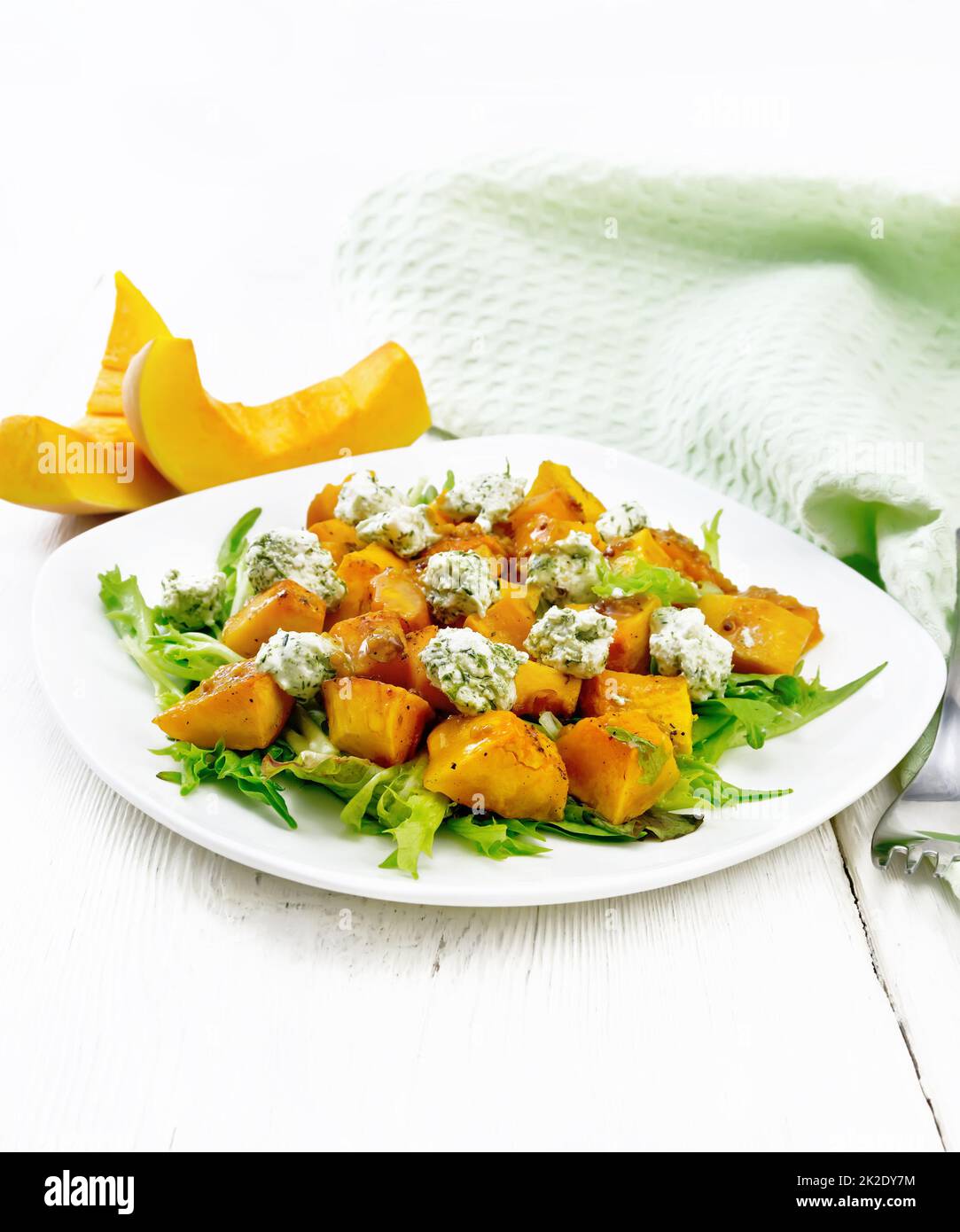 Salad of pumpkin and cheese in plate on light wooden board Stock Photo