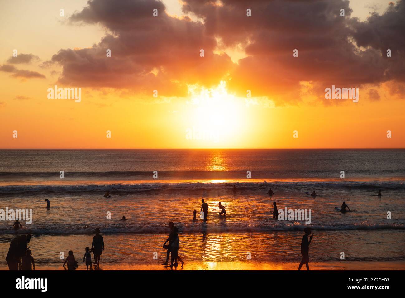 Beautiful sunset and silhouette of different people on the beach Stock Photo