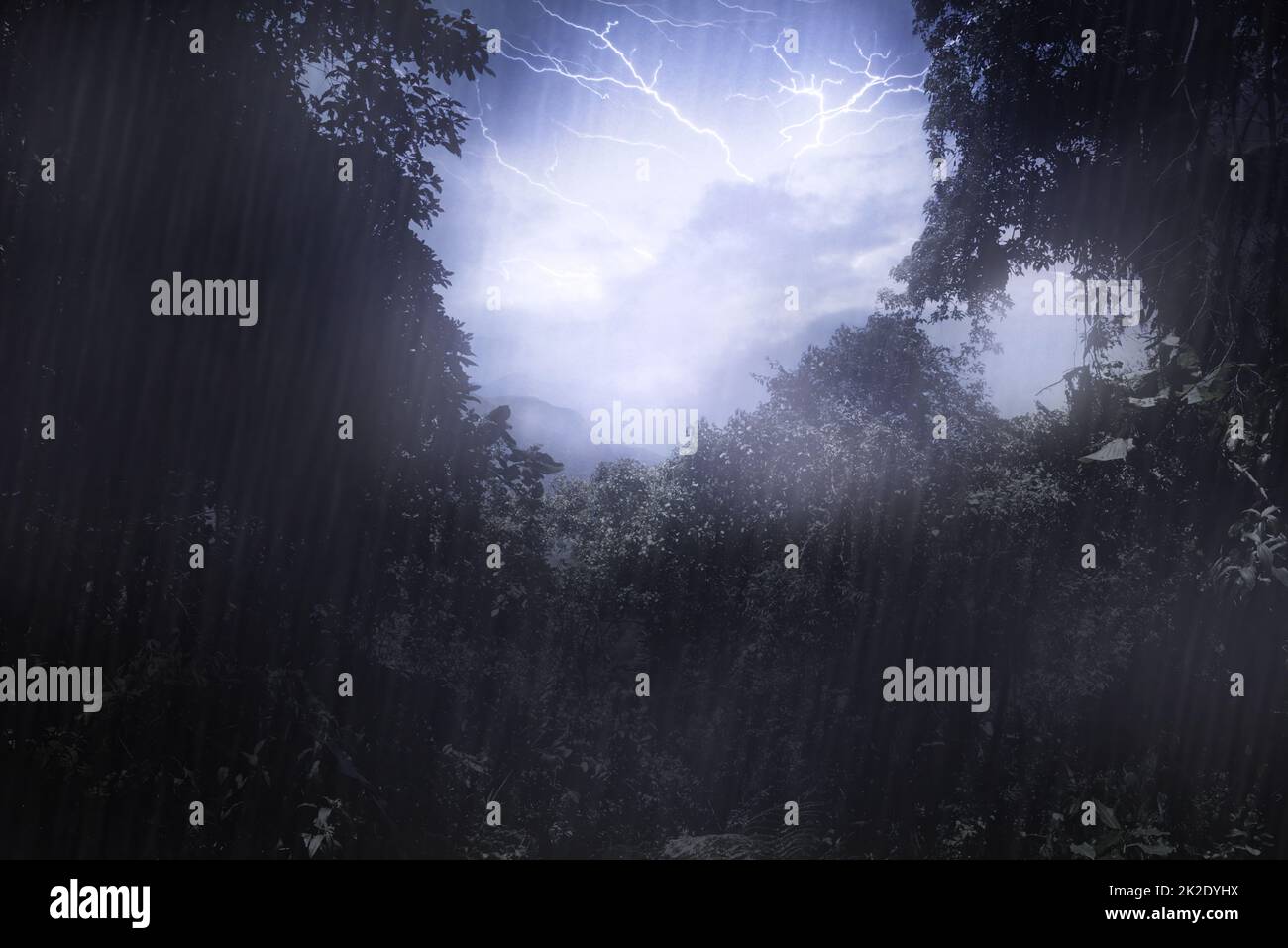 Mother natures mood. Cropped shot a thunderstorm over a mountain as seen through a clearing in the forest. Stock Photo