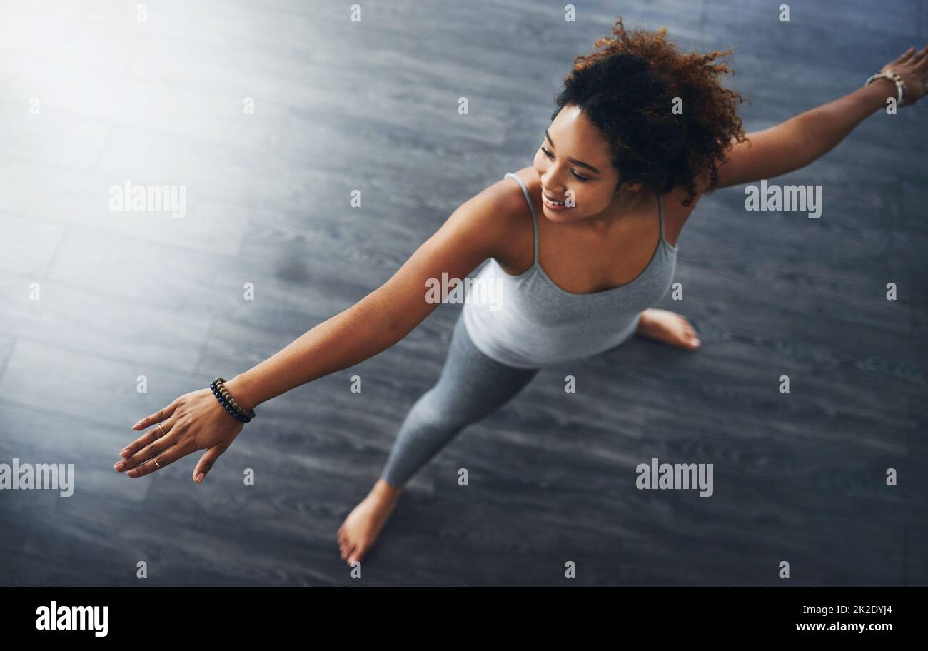 In order to stay fit you have to stretch. High angle shot of a young woman practising yoga. Stock Photo