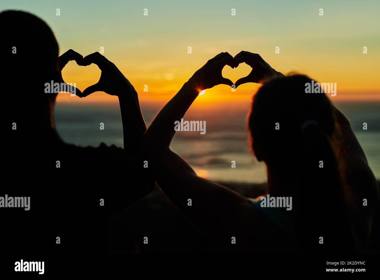 For the love of running. Rearview shot of two young people making heart shapes with their hands. Stock Photo