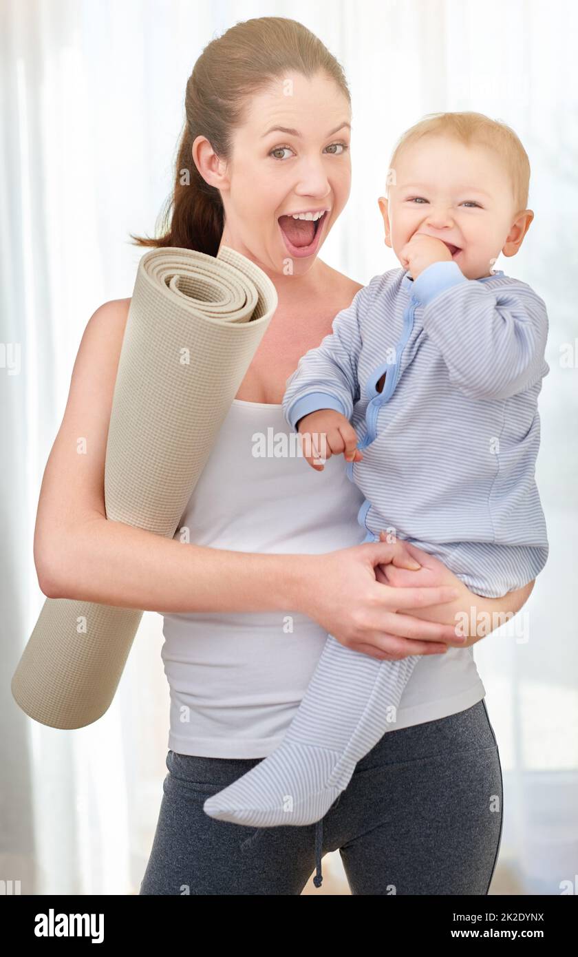 Someones excited for yoga time. Shot of a young woman working out while spending time with her baby boy. Stock Photo