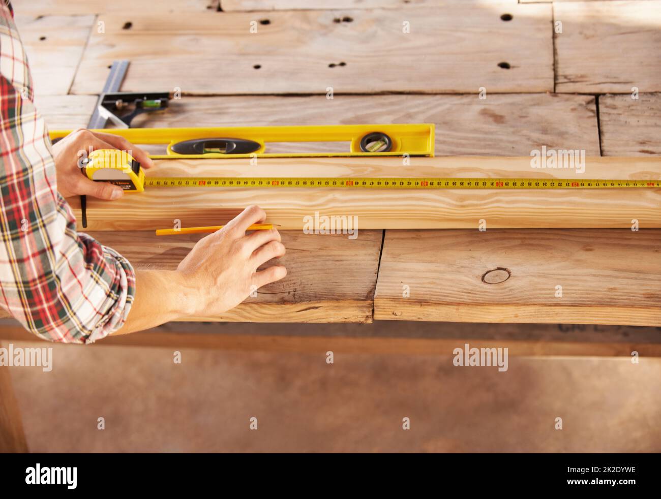 Double checking his measurements. A handyman getting his measurements just perfect with a spirit level and measuring tape. Stock Photo