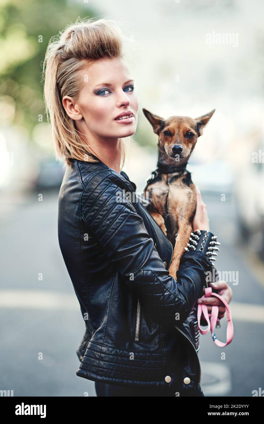 Hes my rock n roll sidekick. Cropped portrait of an edgy young woman holding her small dog outdoors. Stock Photo