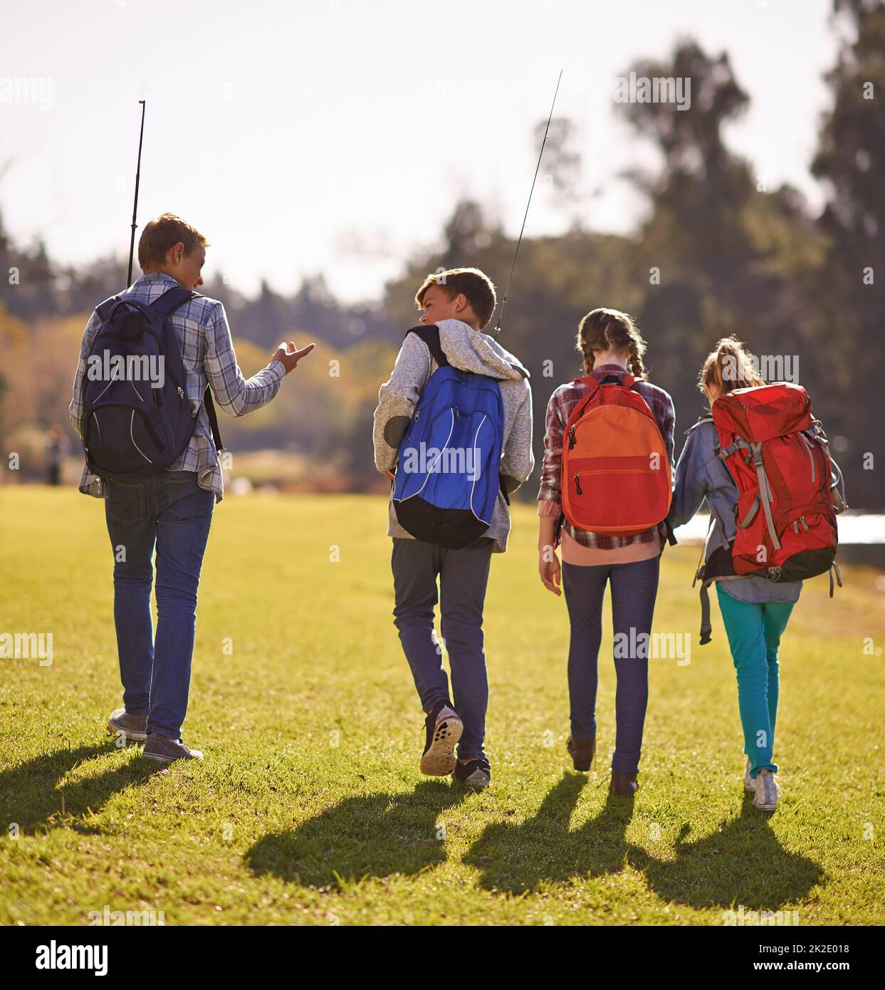 Setting off on an adventure. Shot of a group of children wearing backpacks walking together in nature. Stock Photo