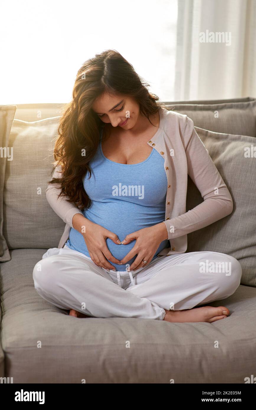 The babys kicks feel like butterfly kisses. Shot of a young pregnant at