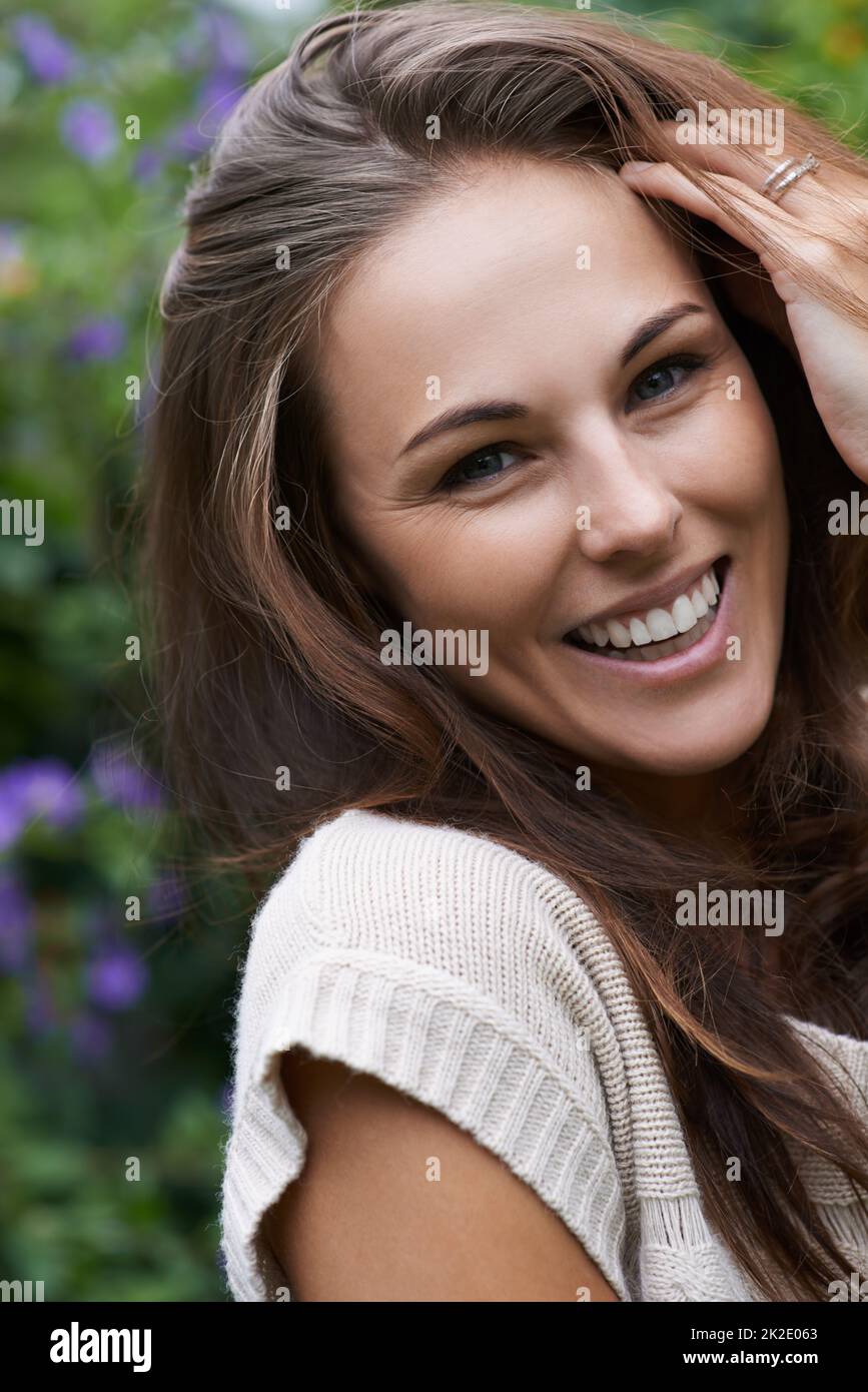 Naturally gorgeous. Portrait of an attractive young woman standing in the garden. Stock Photo