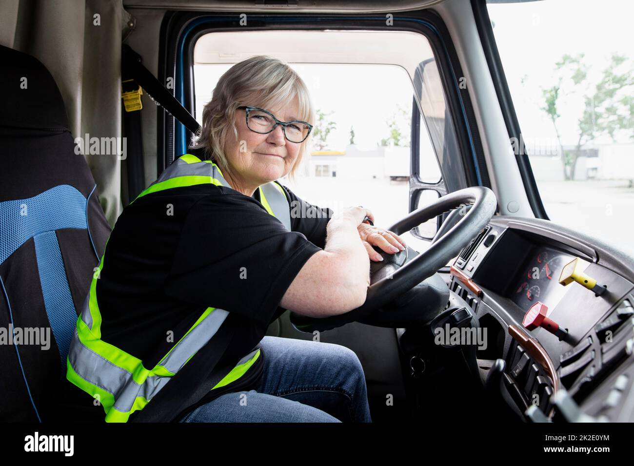 Female trucker sitting at wheel of semi truck Stock Photo Alamy