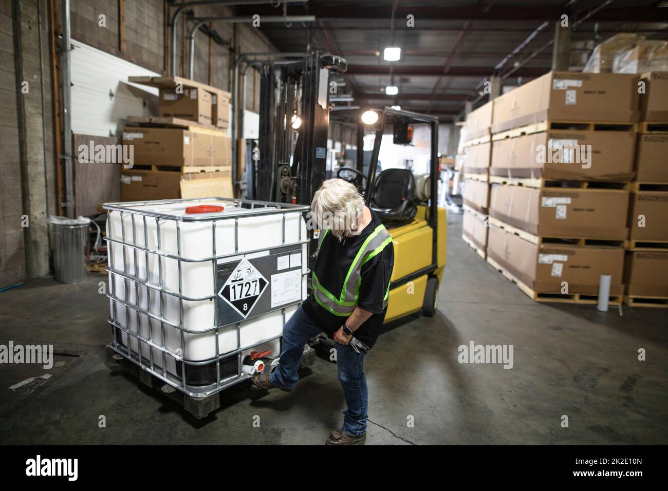 Warehouse owner checking stock on forklift in distribution warehouse