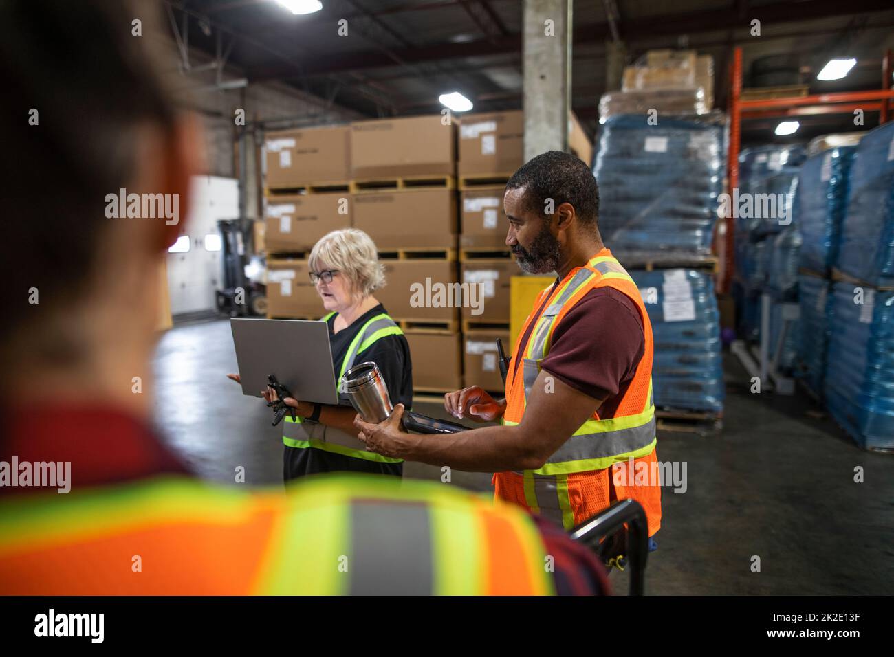 Distribution warehouse owner and workers having team meeting Stock