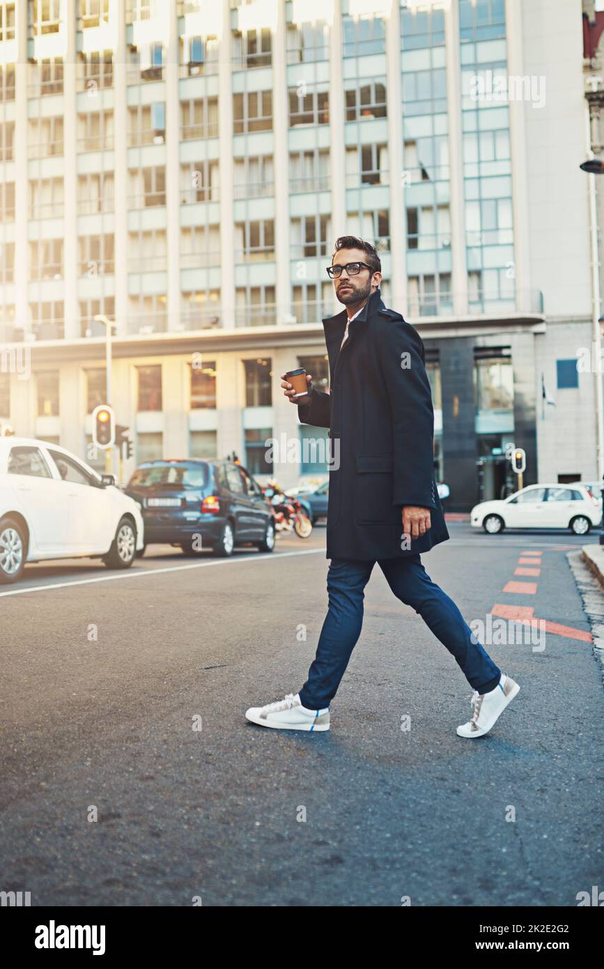 Walking with purpose. Shot of a stylish man crossing a city street. Stock Photo