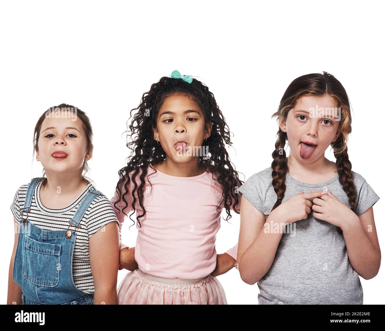 The best part of friendship is having lots of fun. Studio portrait of a group of three girls sticking out their tongues against a white background. Stock Photo