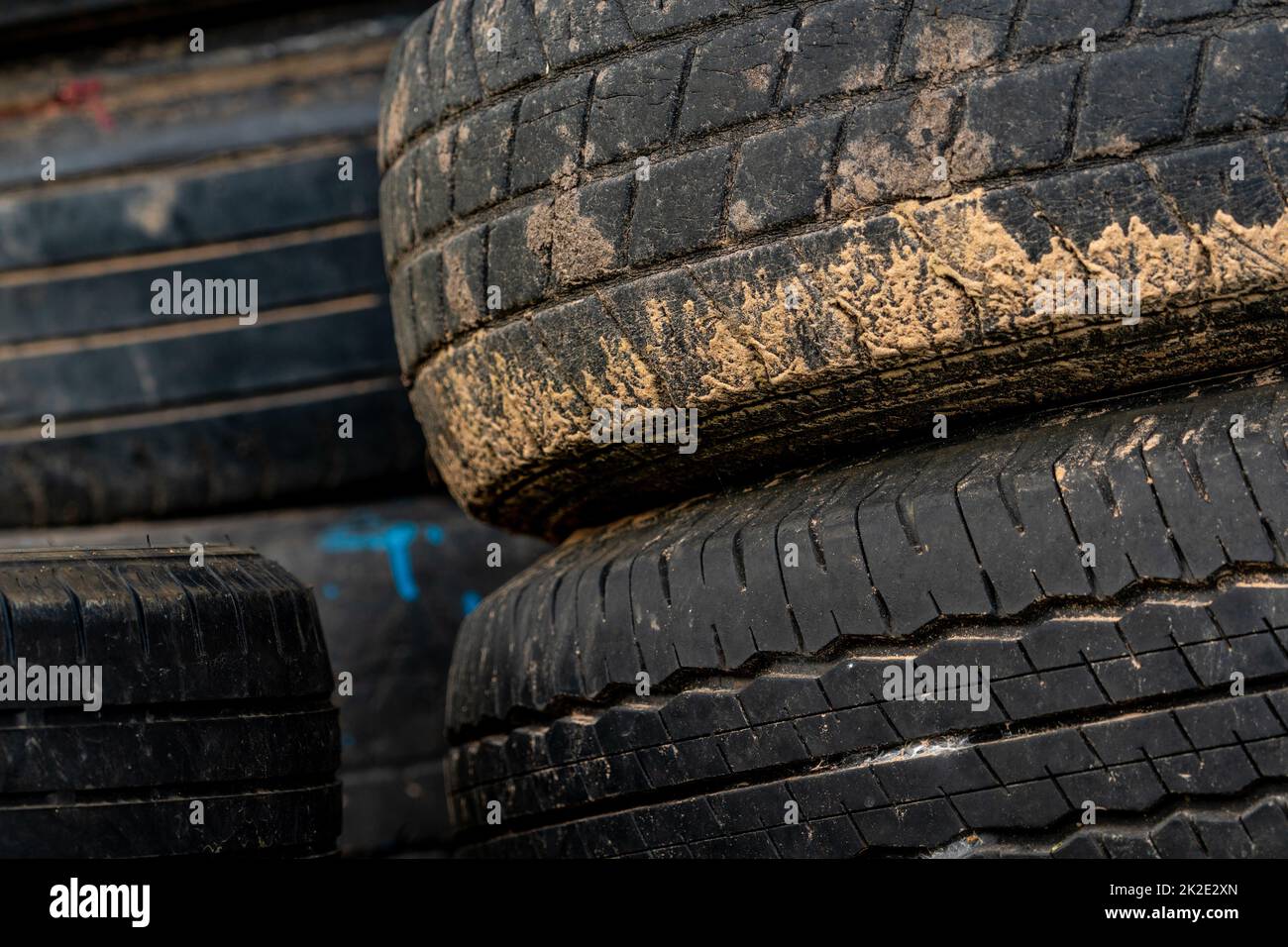 Stack of old tires. Pile of used tires. Black rubber tire of car. Dirty used tyres. Closeup old tyres waste for recycle. Closeup tread of an old dirty tyre. Change car tire for safety concept. Stock Photo