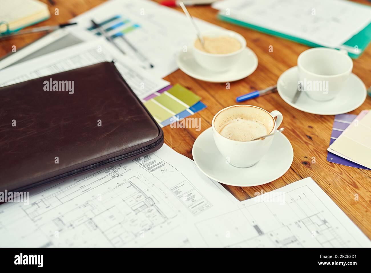 An architects natural habitat. Shot of cups of coffee, blueprints and