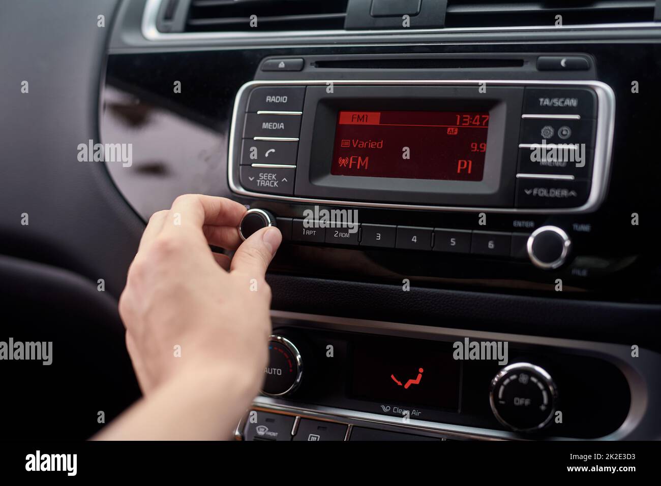 Tuning the stereo. Closeup shot of a driver tuning a car radio. Stock Photo