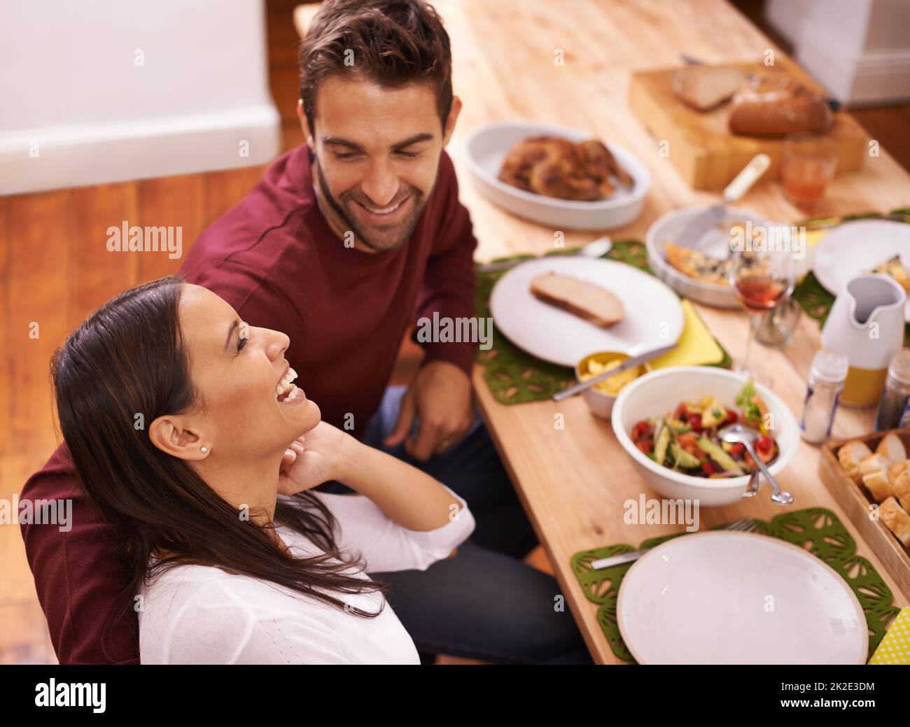 Love and food - two of the best things in life. A happy couple enjoying a family meal around the table. Stock Photo