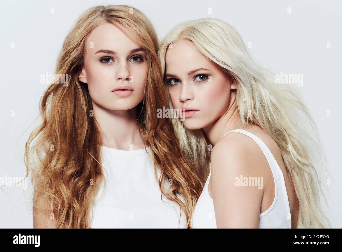 Looking casually beautiful. Studio portrait of two young models against a white background. Stock Photo