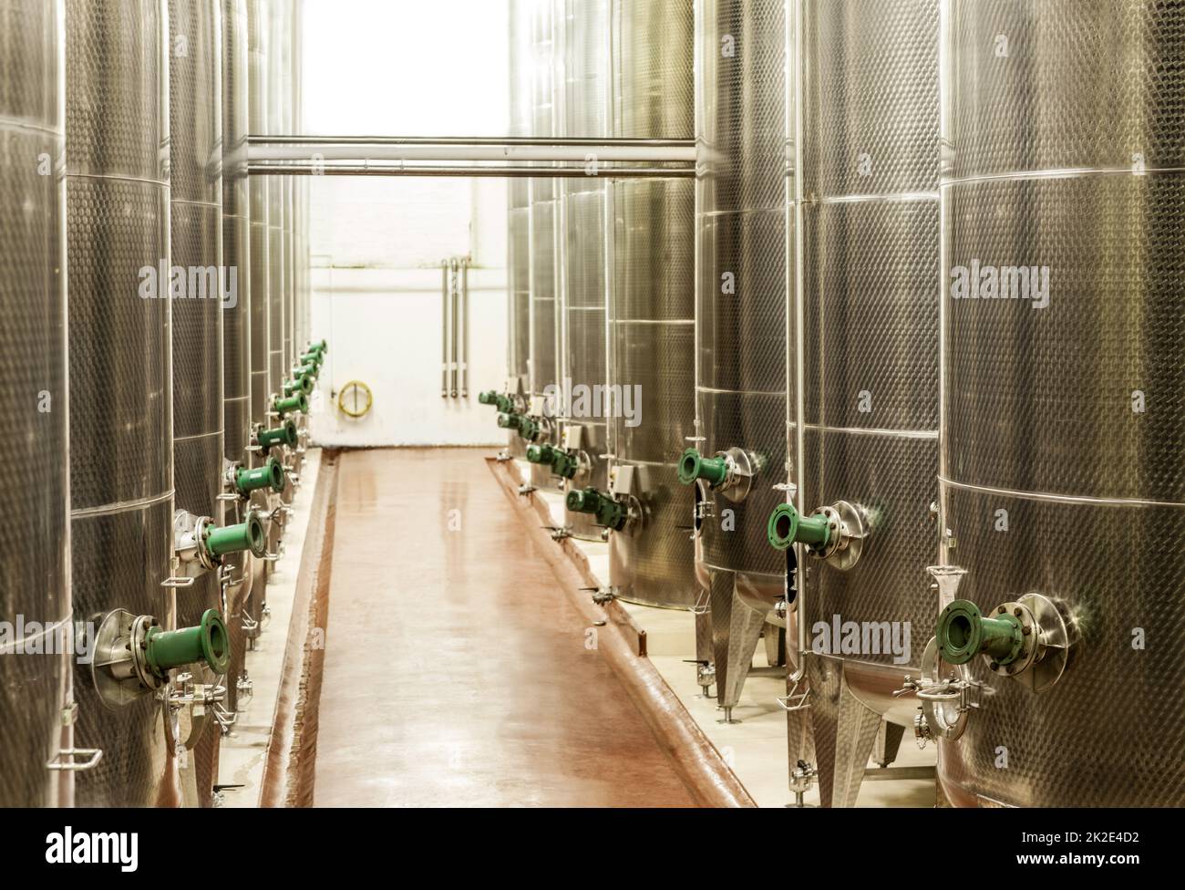 Producing wine on a large scale. Shot of the fermentation vessels inside a winemaking factory. Stock Photo
