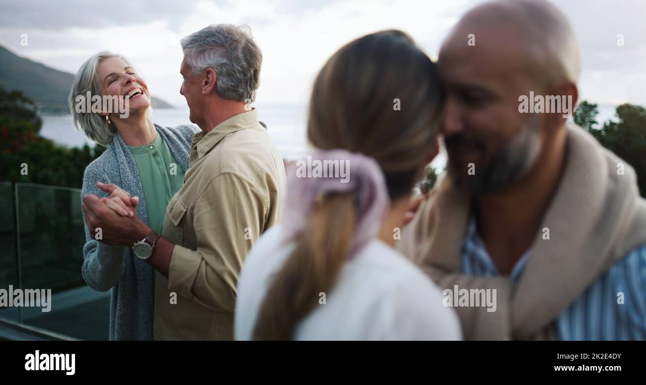 The skies may change but real love stays the same. Shot of two happy couples dancing outdoors. Stock Photo