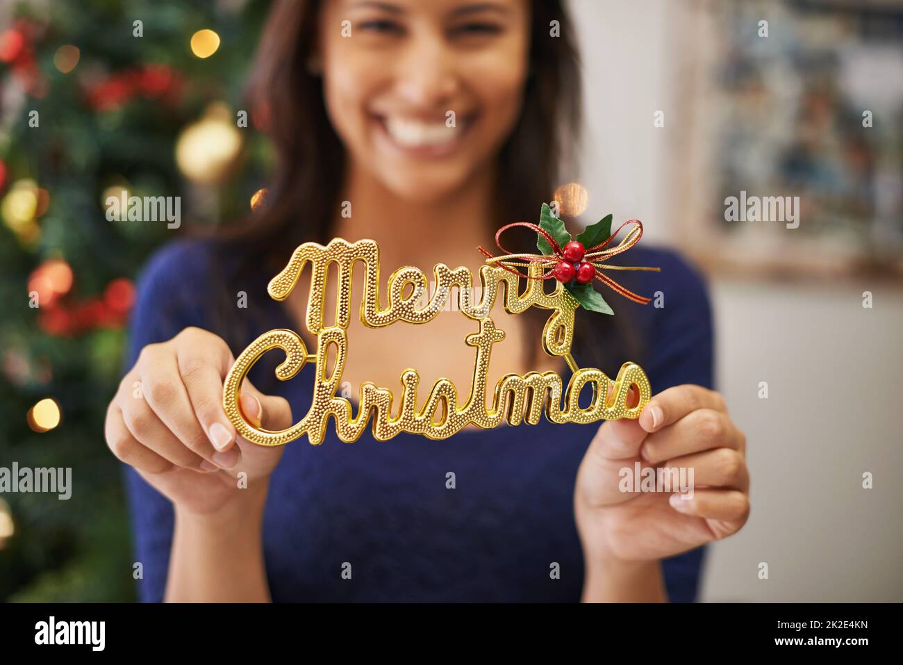Spreading a little festive cheer. Cropped shot of a beautiful young woman holding up a festive decoration. Stock Photo