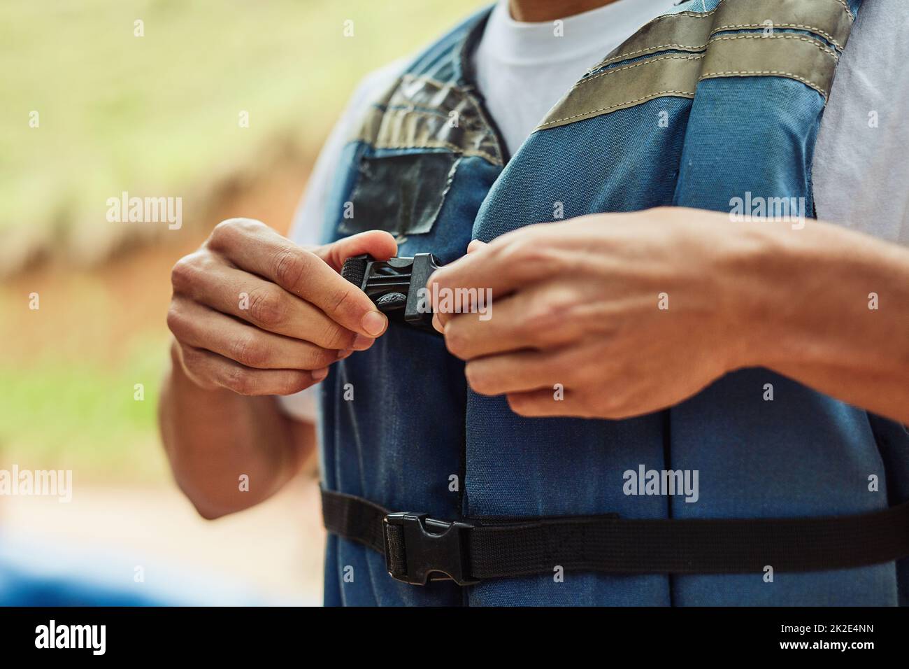 Safety comes first. Cropped shot of a man putting on a life jacket for
