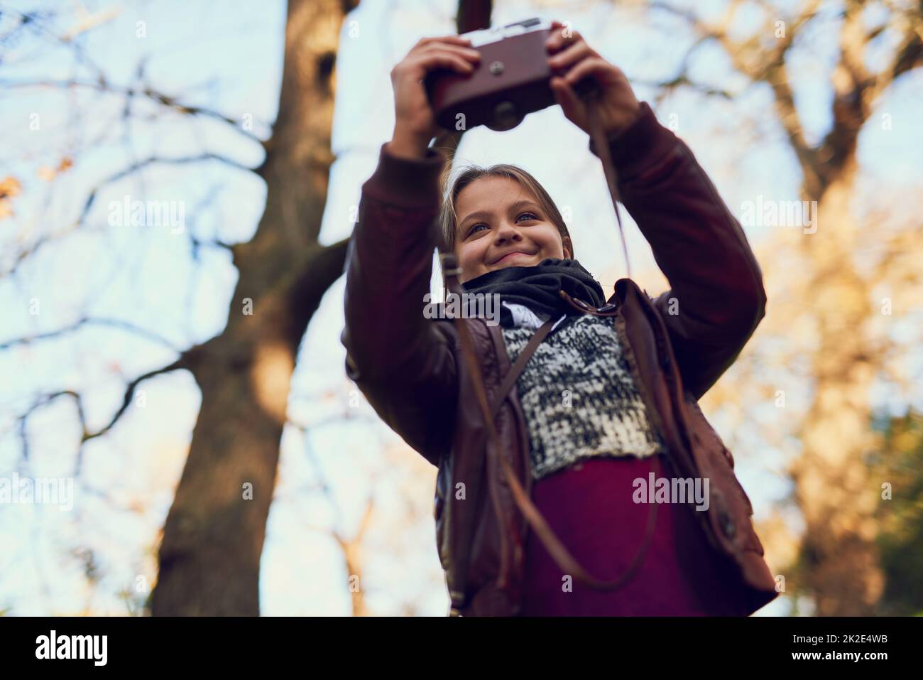 Out on an exploration. Shot of a young girl taking a selfie with a vintage camera outdoors. Stock Photo