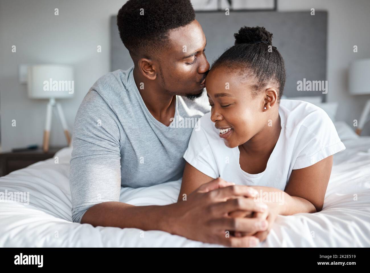 Nothing beats the feeling of being in love and being loved. Shot of an affectionate young couple relaxing on their bed together at home. Stock Photo