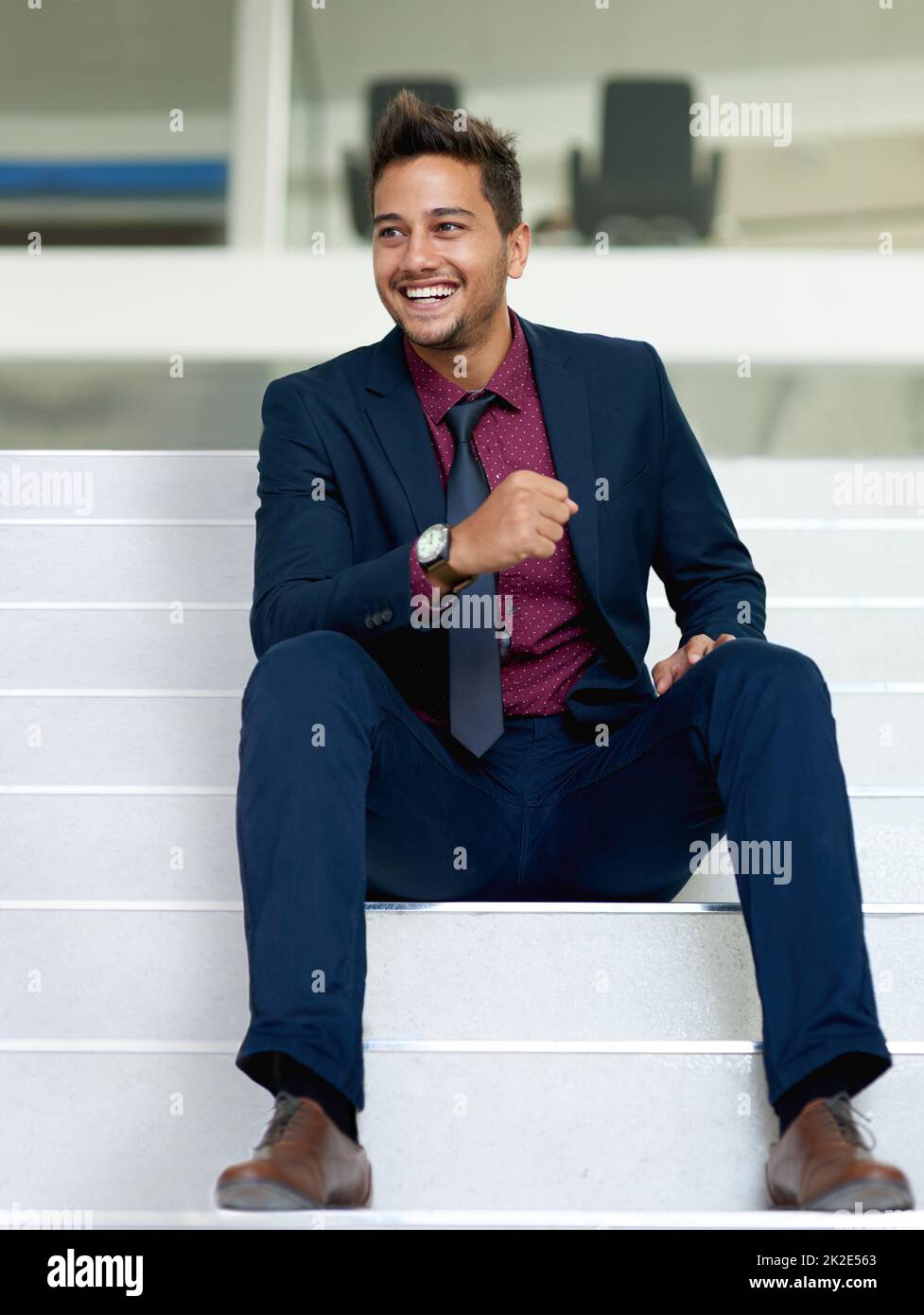 Do more than you dream. Shot of a handsome young businessman sitting on a staircase in an office. Stock Photo