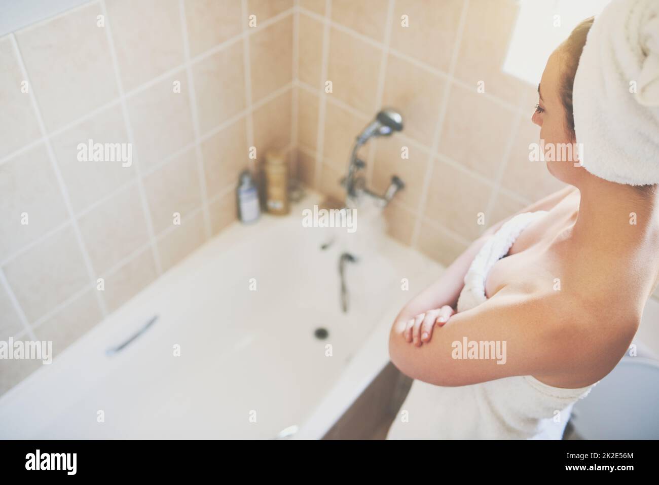 I aim to be water wise. Cropped shot of a beautiful young woman getting ready to take a bath at home with the words Be water wise illustrated above. Stock Photo