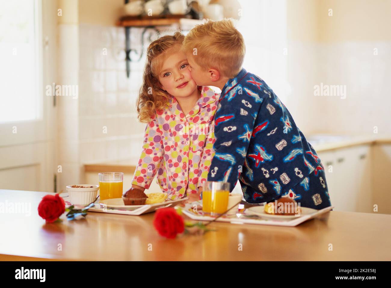 Thanks little sis for helping with breakfast. Cropped shot of a little boy giving his sister a kiss on the cheek at home. Stock Photo