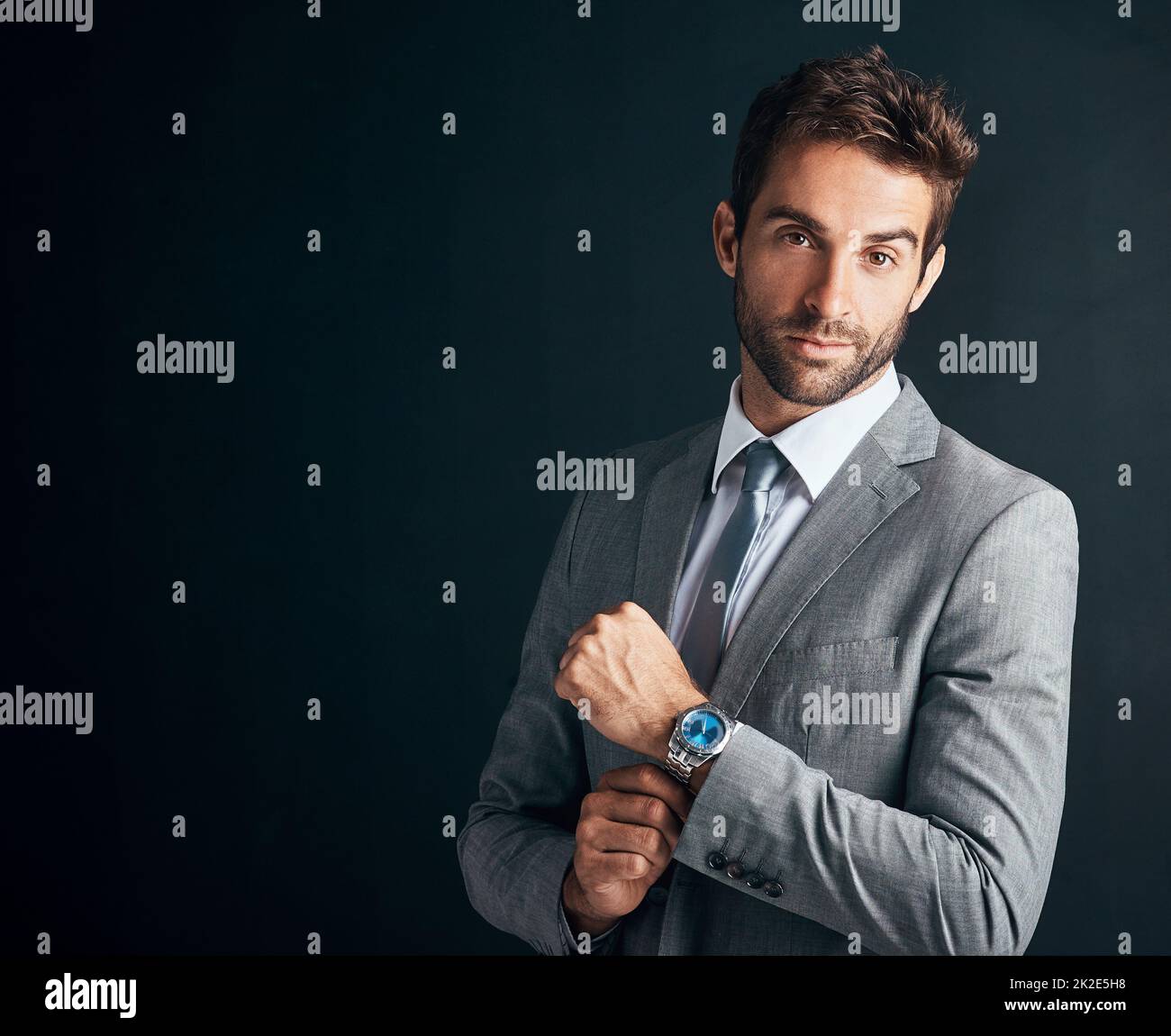 Dress like you mean business. Studio shot of a confident and stylishly dressed young businessman against a black background. Stock Photo