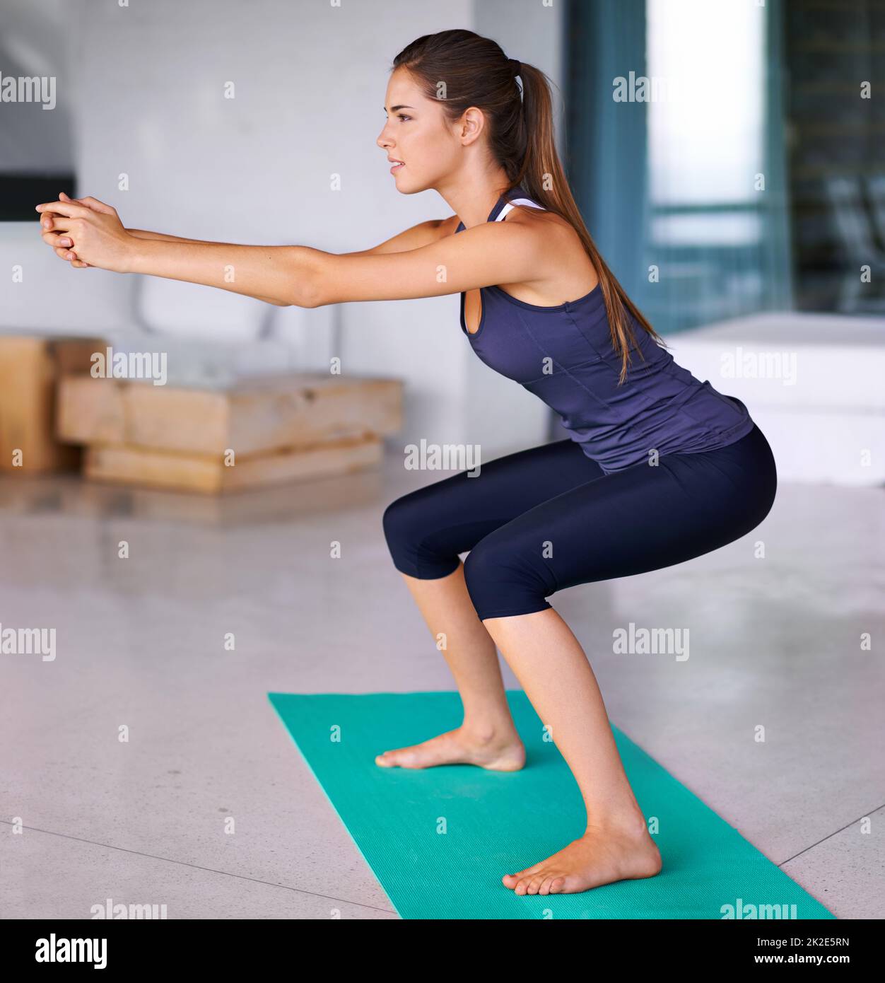 Where balance and strength meet. A side shot of a beautiful young woman doing exercise on an exercise mat. Stock Photo