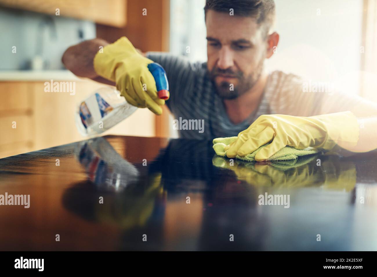 Portrait of smiling man cleaning the kitchen worktop at home Stock Photo -  Alamy