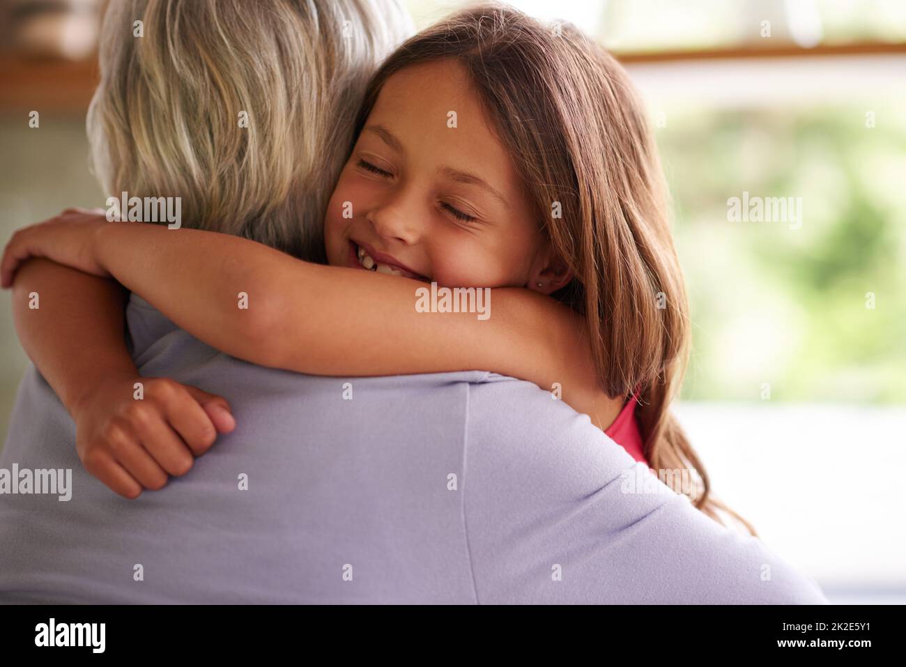 Giving granny a big hug. Shot of a cute little girl hugging her grandmother. Stock Photo