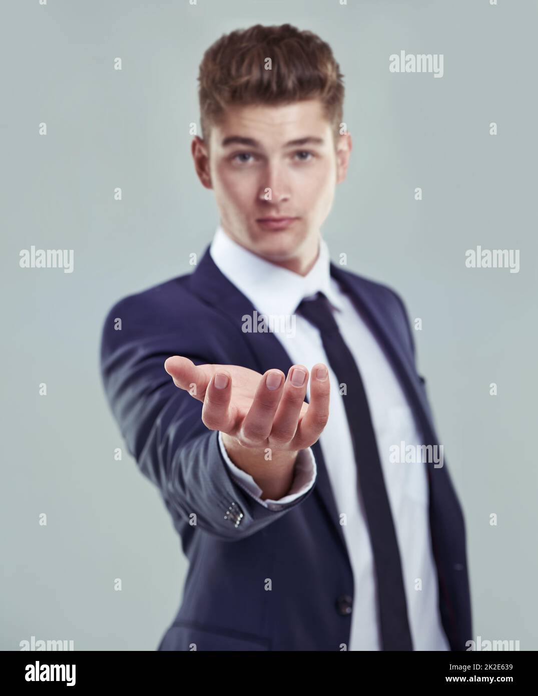Welcome to the digital age. Concept studio shot of a young businessman standing with his open palm raised to the camera. Stock Photo