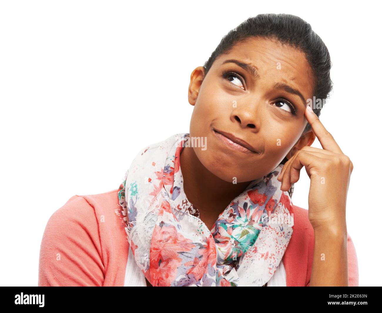 Wishing she could remember.... Cute young woman scratching her head and looking up thoughtfully. Stock Photo