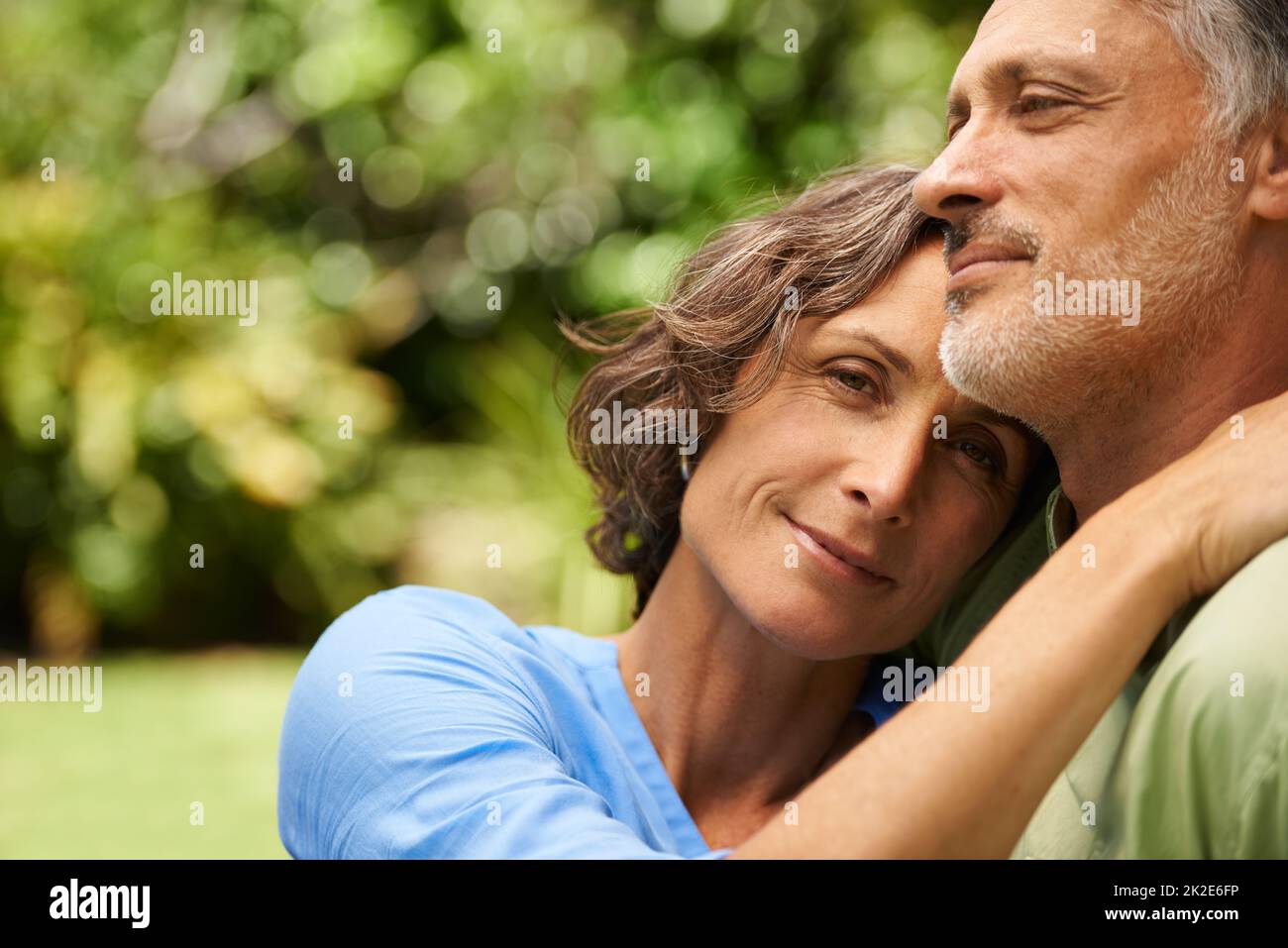 Hes everything I could ever want. A cropped portrait of a happy mid adult woman sitting affectionately with her husband outdoors. Stock Photo