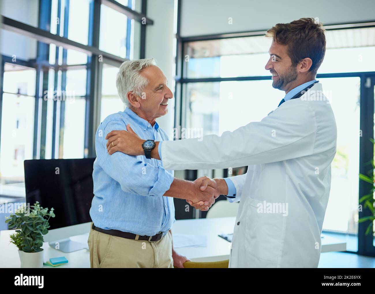 These moments make the job all worth it. Shot of a cheerful senior man shaking hands with his doctor in a clinic. Stock Photo