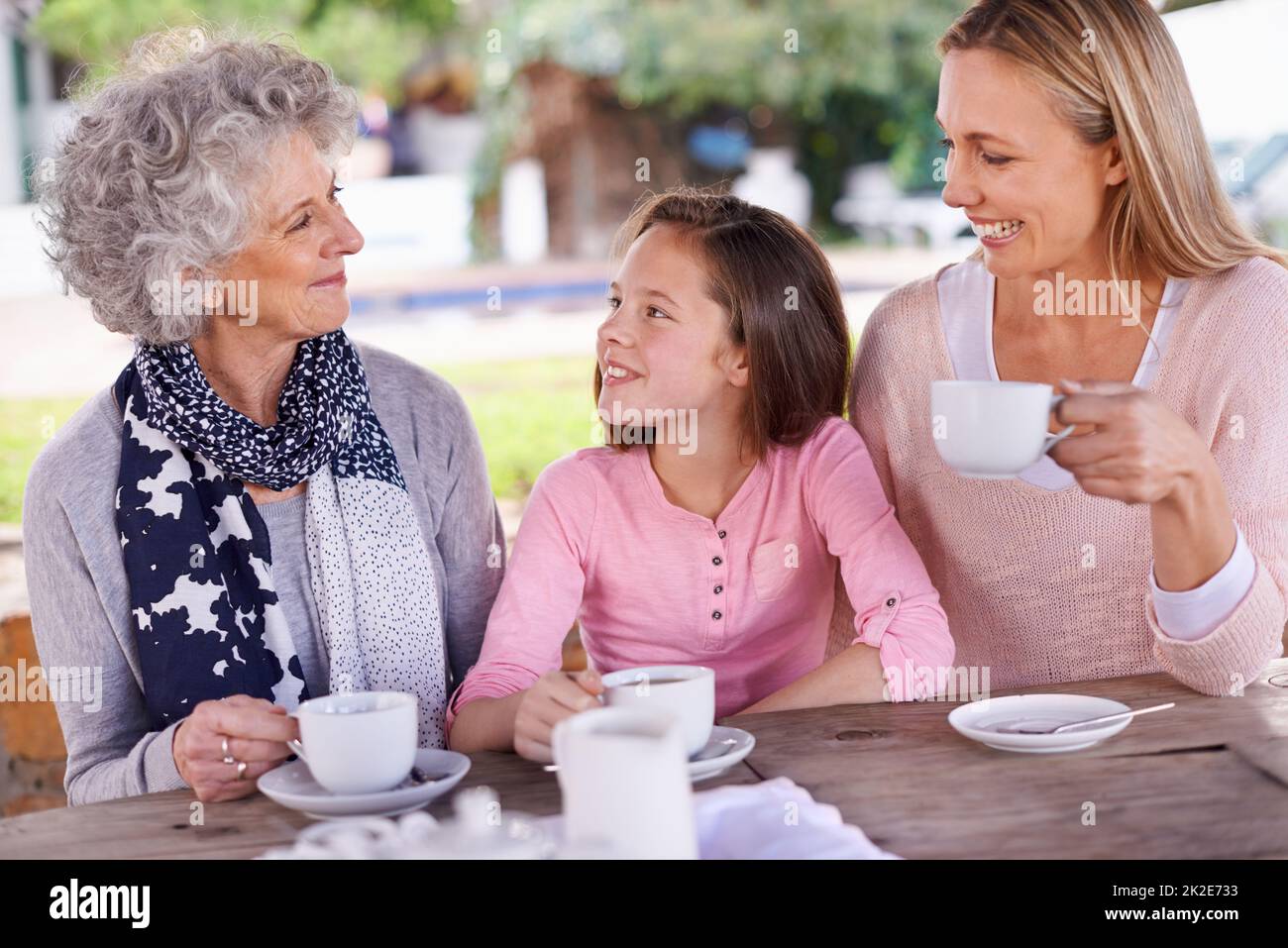 Bonding time for the girl. Shot of three generations of the woman of the women of a family having tea outside. Stock Photo