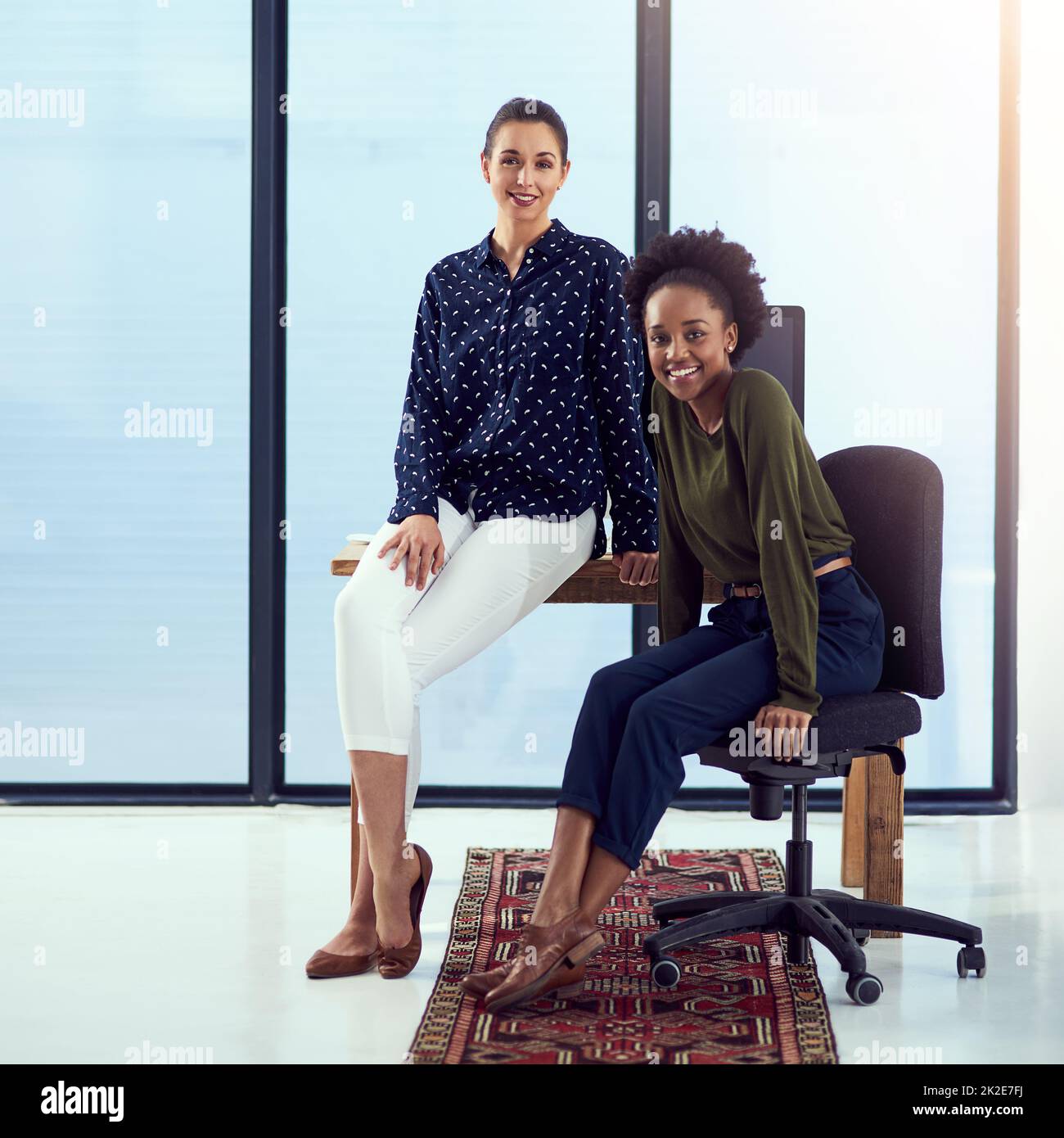 Weve got the job covered. Portrait of two young designers at a work station in front of a window. Stock Photo