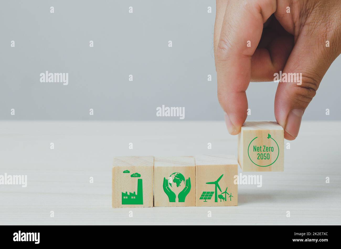 Wooden cubes with net zero and carbon neutral green factory icon symbol background and copy space. Stock Photo