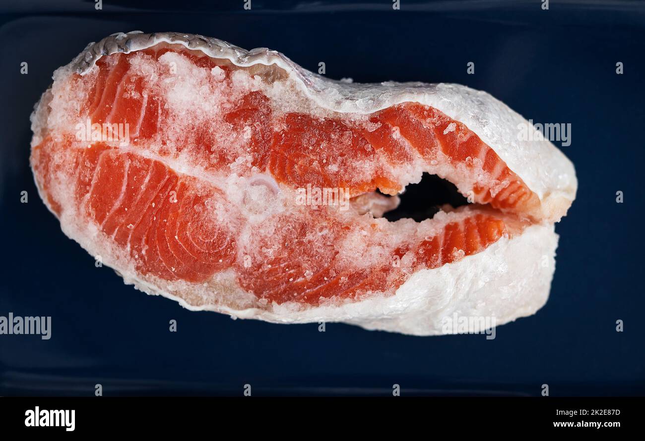 Fresh raw red salmon steak with large coarse pink salt prepared for grilling. Healthy seafood food. Healthy food. Stock Photo