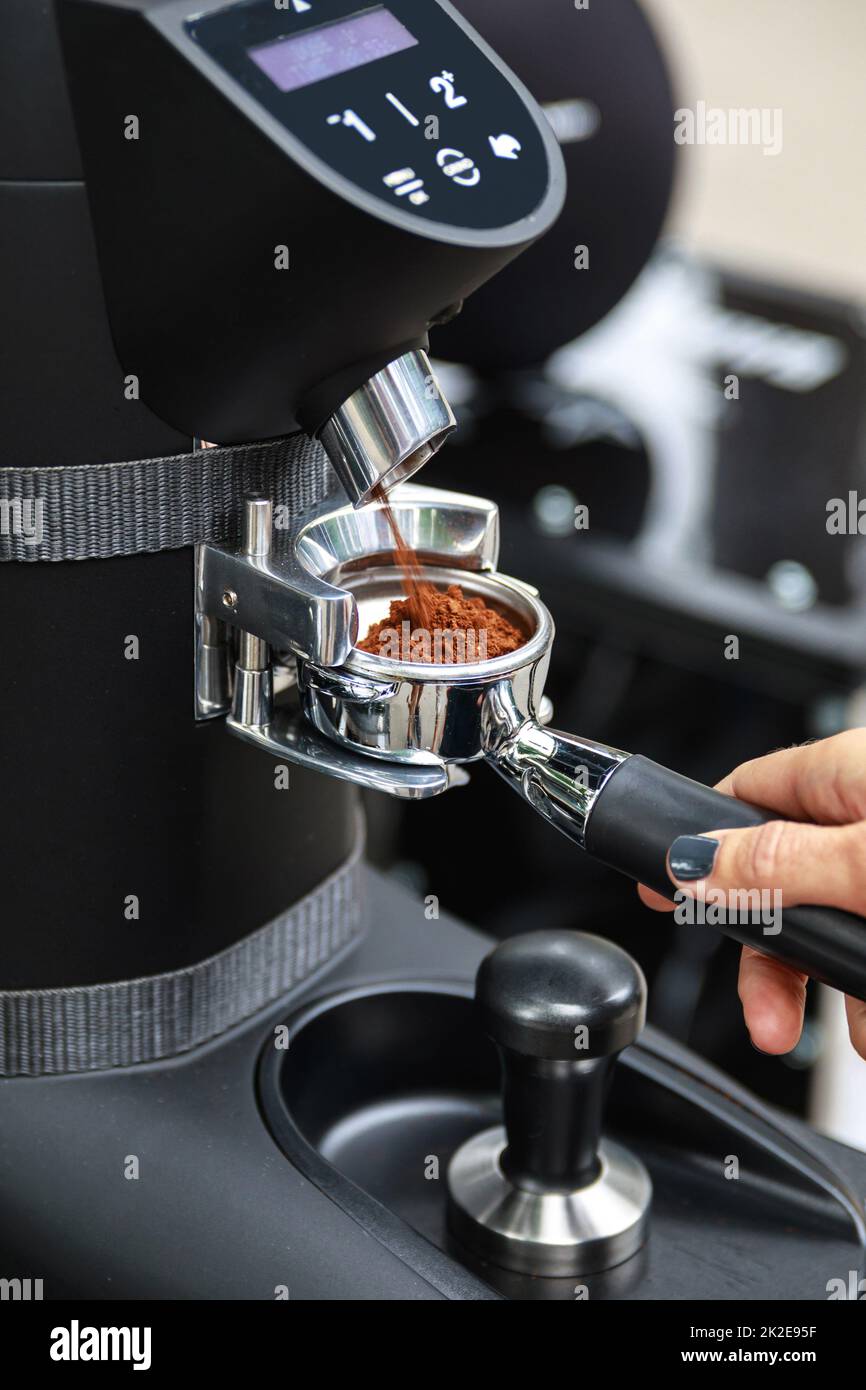 Barista grind coffee beans into the portafilter Stock Photo Alamy